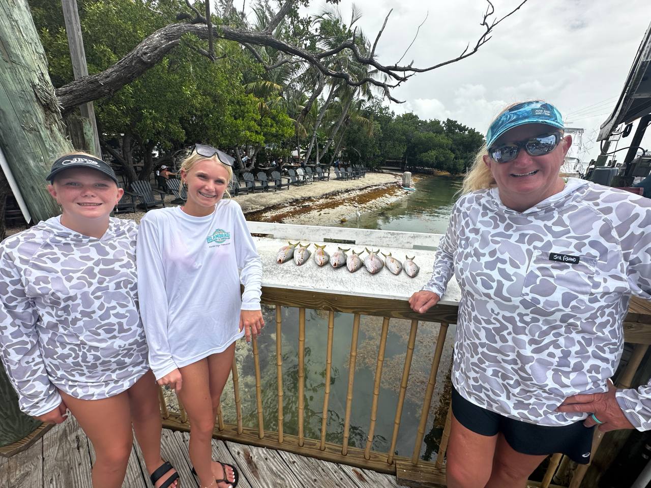 Lily, Ivy, and Mark with the yellowtail catch at Robbie's