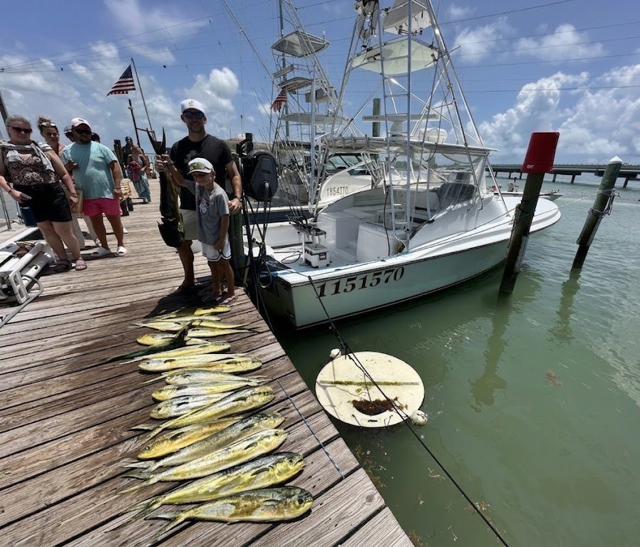 Alec and Gates with the day's mahi laid out on the dock